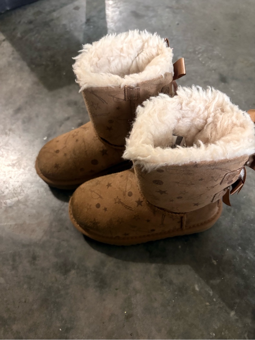 Tan kids Uggs with bows on the back